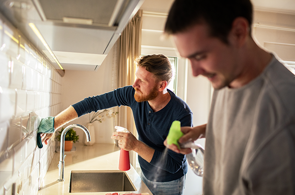 Zwei Männer putzen gemeinsam die Küche