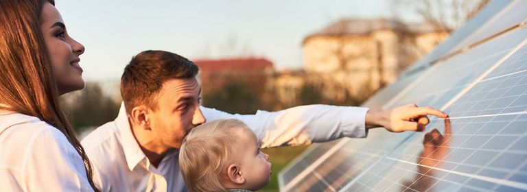 Pärchen mit kleinem Kind sieht sich Photovoltaik an