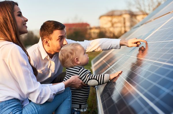 Pärchen mit kleinem Kind sieht sich Photovoltaik an
