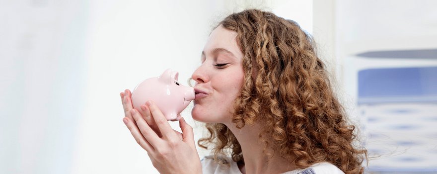 Frau küsst Sparschwein