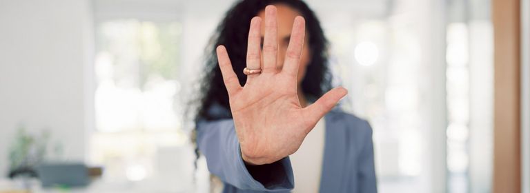 Frau streckt Handfläche nach vorne aus, um Stopp zu signalisieren 