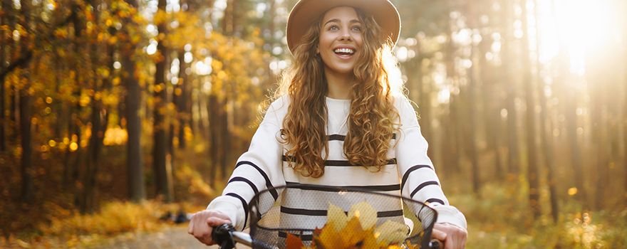 Frau fährt Fahrend in einem Herbstwald