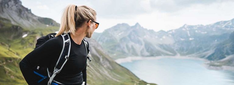 Junge Frau beim Wandern in den Bergen mit Blick auf einen See