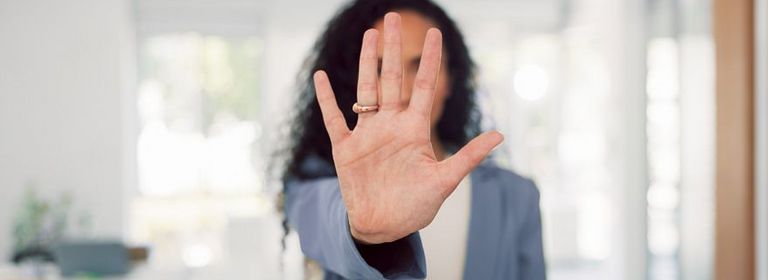 Frau streckt Handfläche nach vorne aus, um Stopp zu signalisieren 