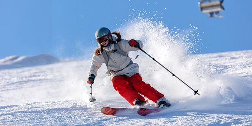 Skifahrerin fährt Piste hinunter