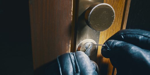 Hände, die ein Türschloss aufbrechen. Was sollen Sie nach dem Einbruch tun.